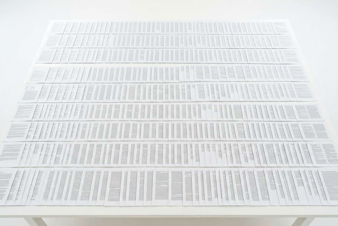 Hundreds of printed articles laid out on a table